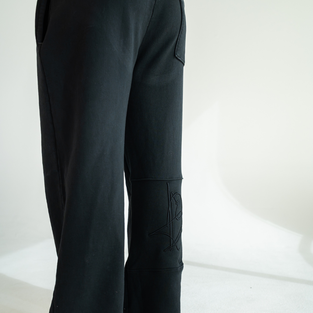 Black DISRPT signature heavyweight sweatpants rear angle view on white background with minimalist design and relaxed fit